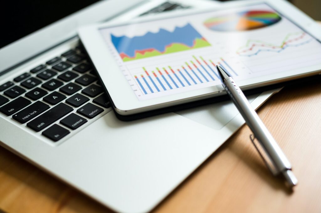 Tablet displaying charts on laptop with pen