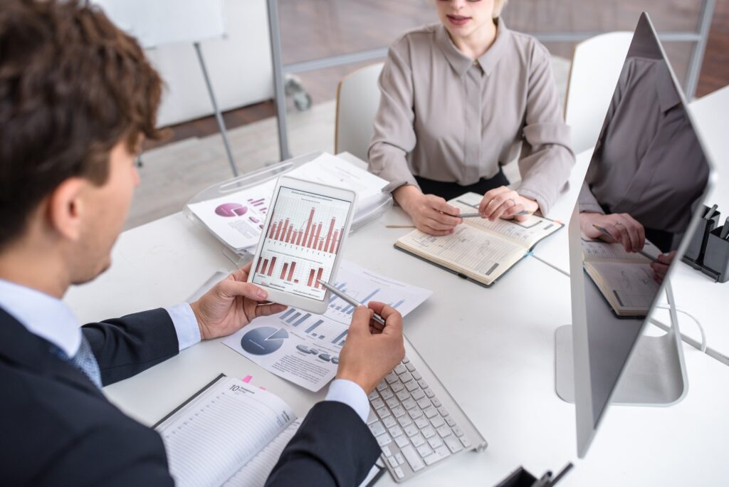Professionals reviewing financial charts on tablet