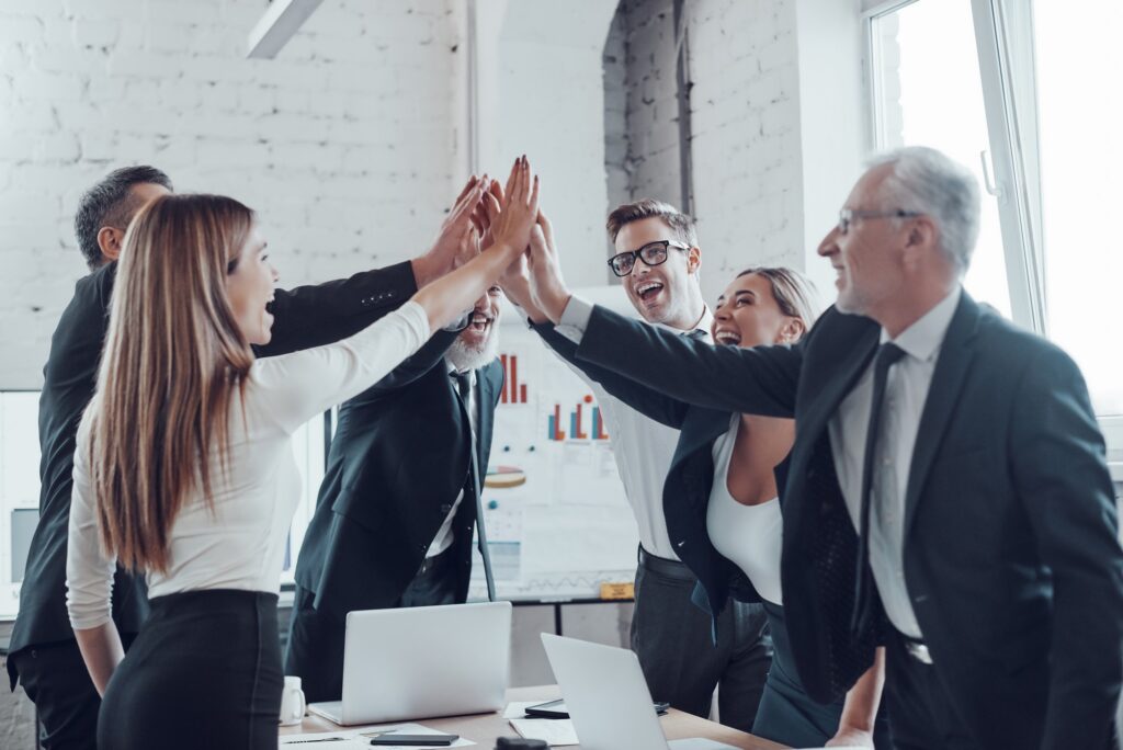 Business team high-fiving in modern office