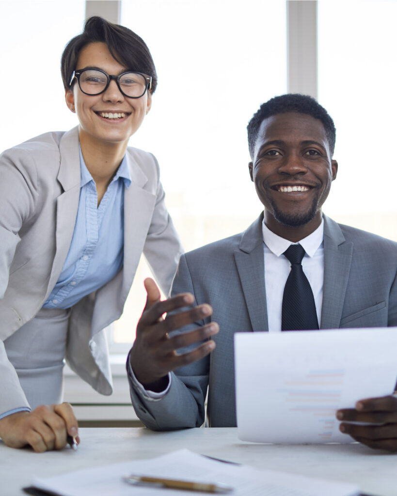 Two smiling business colleagues at desk