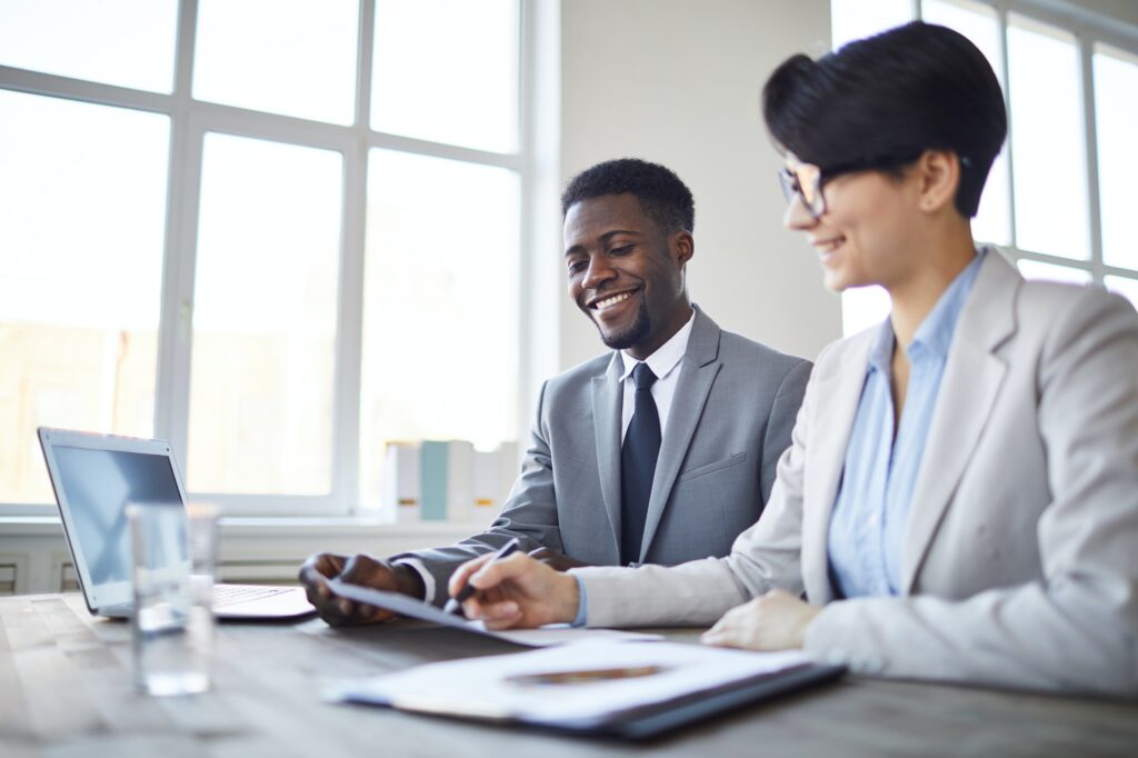 Two colleagues reviewing documents in bright office