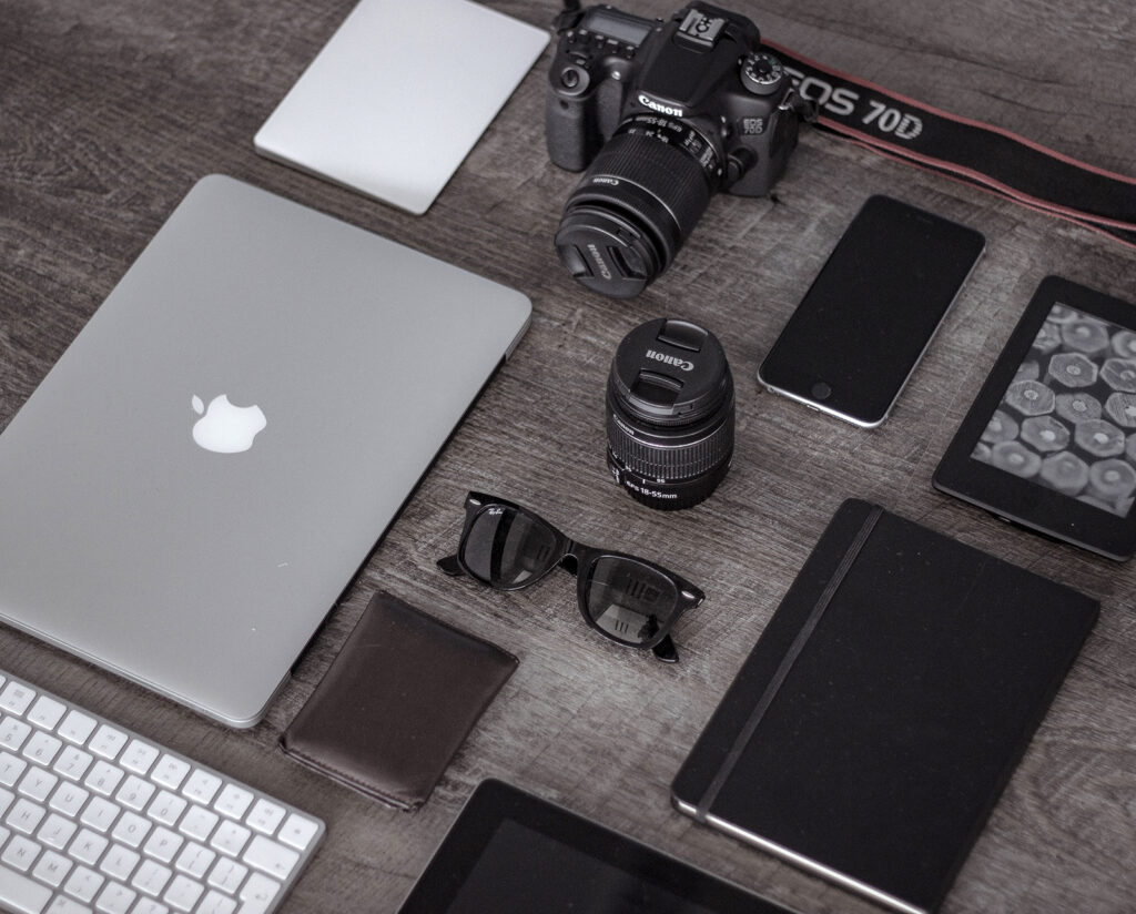 Flat lay of camera, laptop, phone, and accessories