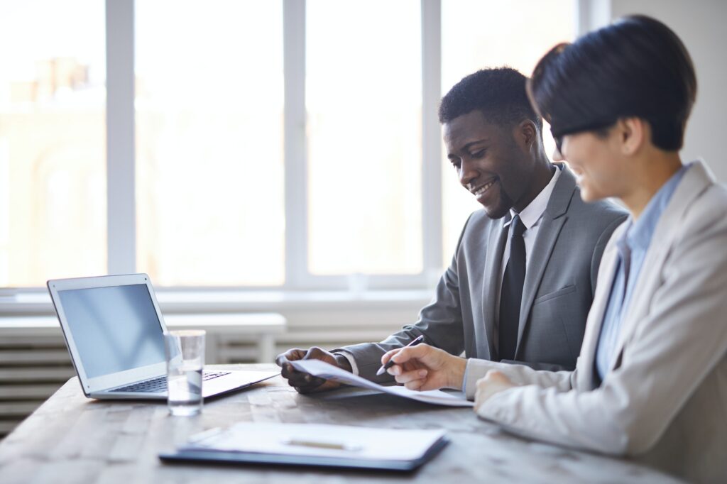 Two professionals reviewing documents at desk