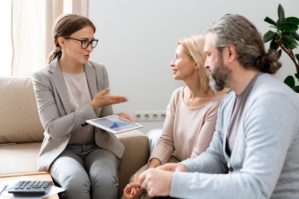 Financial advisor consulting mature couple with tablet